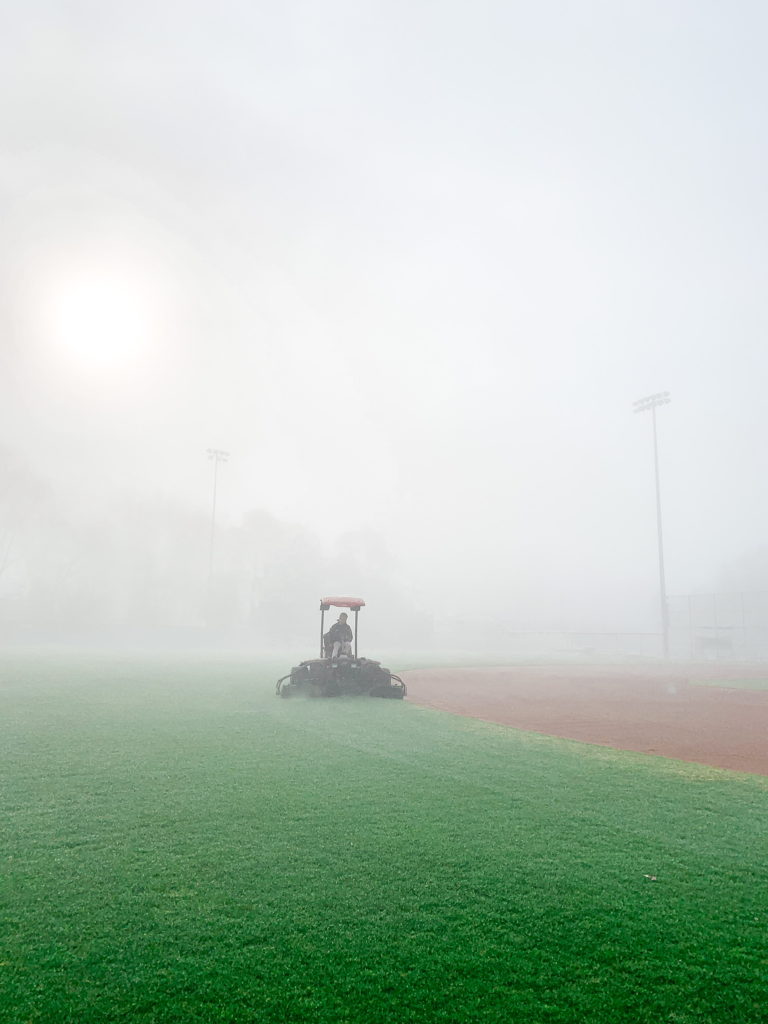 Woman driving a tractor on a field.