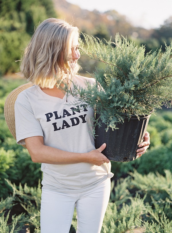Those Plant Ladies, girl with PLANT LADY shirt and holding a potted shrub