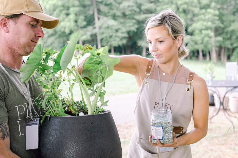 Fawn of Those Plant Ladies adding Nelsons Plant Food to a flowering container.