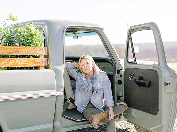 Heather from Those Plant Ladies sitting in a broken-down pickup truck.
