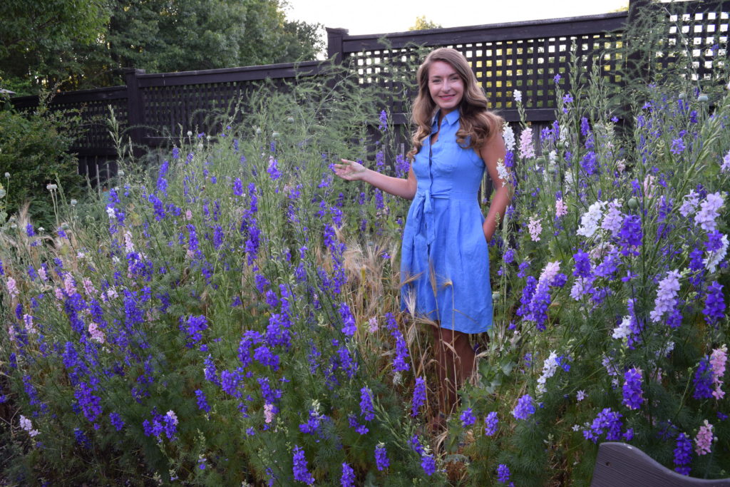 Brie Arthur standing among the plants.