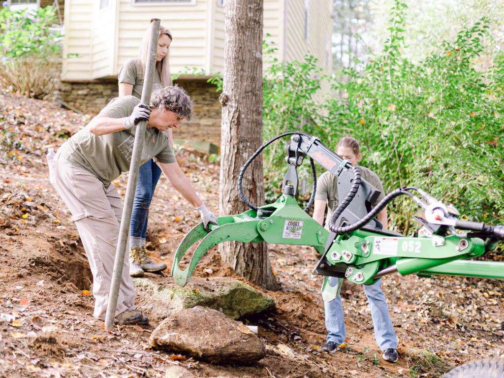 Those Plant Ladies using the Avant Loader 630 with attachments to add large boulders to the hillside.