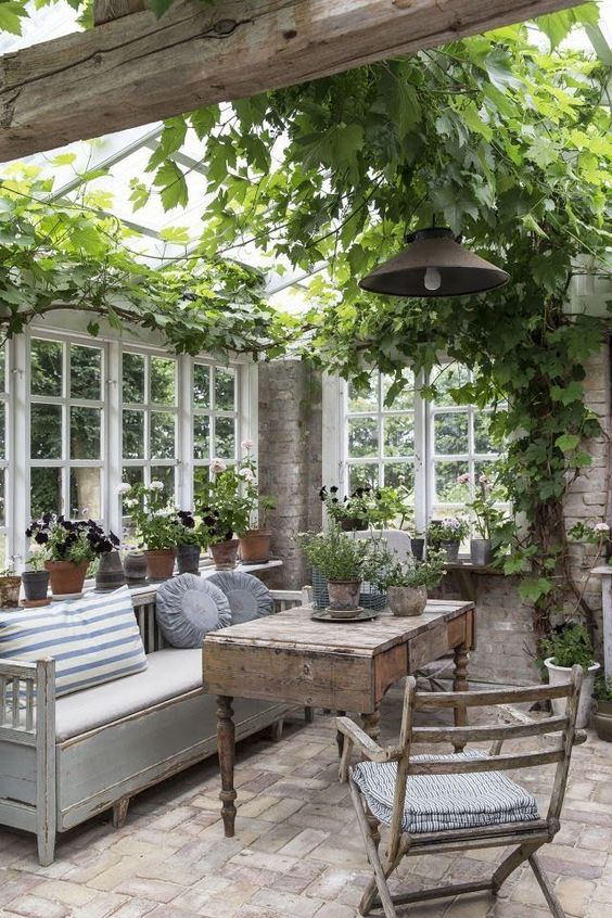 Stone greenhouse with a sitting area.