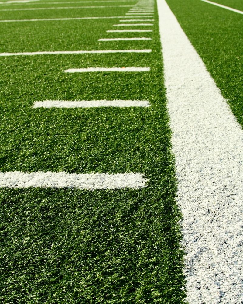 A close-up of a football field with painted hashmarks.