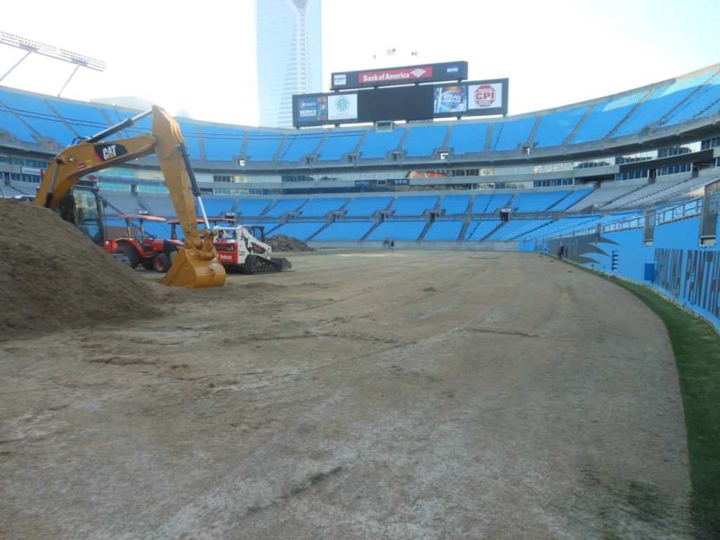 The turfgrass being installed with large equipment at the Carolina Panthers' Stadium.