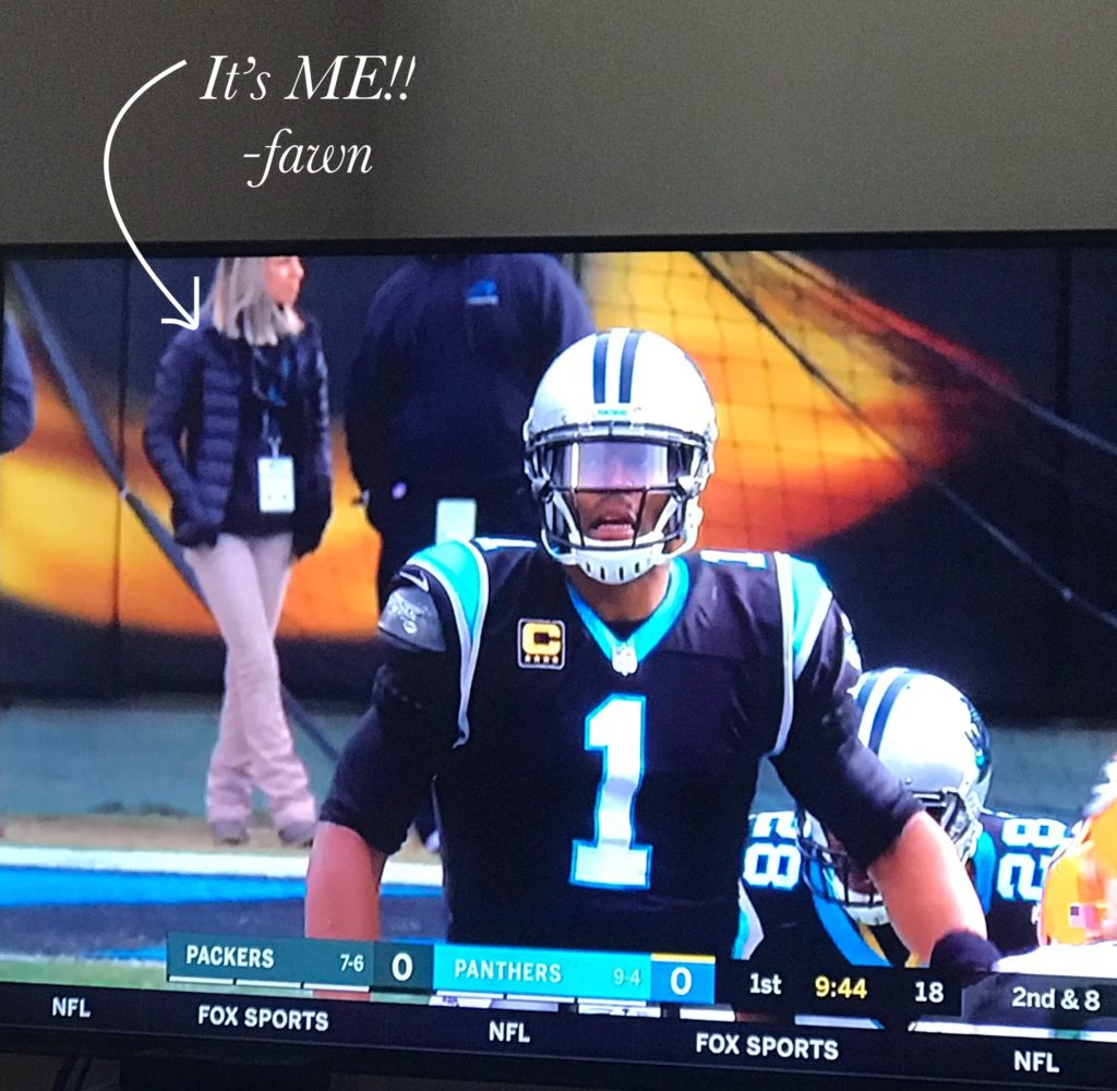 Fawn of Those Plant Ladies in teh background of a television shot of quarterback Cam Newton.